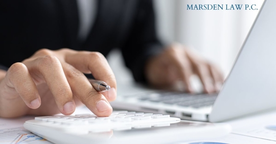 person working on a laptop and calclulator